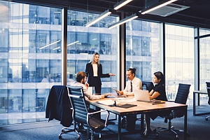 Employees sitting together at a table getting expert IT consulting and managed it services help