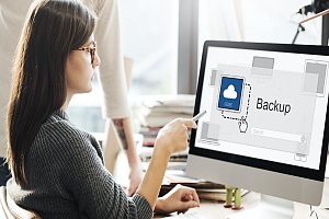 a woman with data backup on the screen of her desktop computer