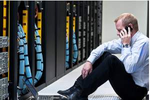 A worried technician in a Data storage center.Disaster Recovery is important for Business