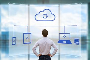 An illustration of cloud synchronizing between devices as a person looks up data backup to help protect their businesses