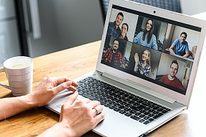 person sitting at a table in a meeting while working remotely