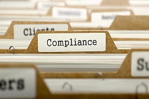 the word compliance on a file in a file cabinet