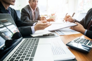 computer on table with men finding out exactly What Is IT Consulting