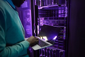 cropped shot of african american data engineer holding laptop