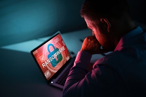 businessman looking at laptop with ransomware