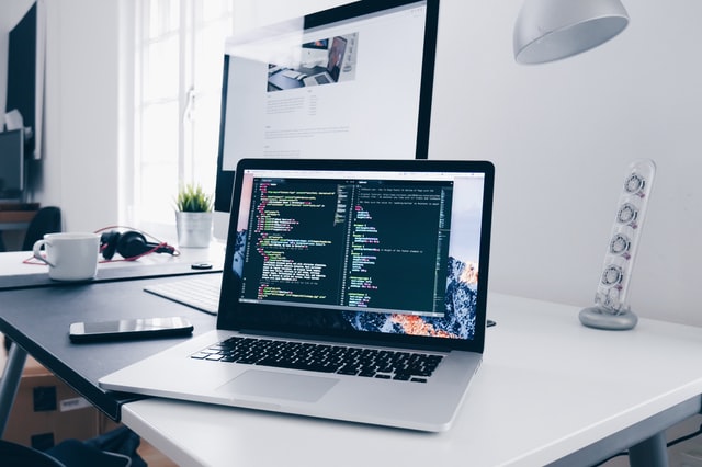 a macbook with lines of code on its screen