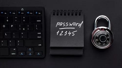 An image showing a keyboard, a notepad with a written password, and a lock, showing an example of unsafe password practices